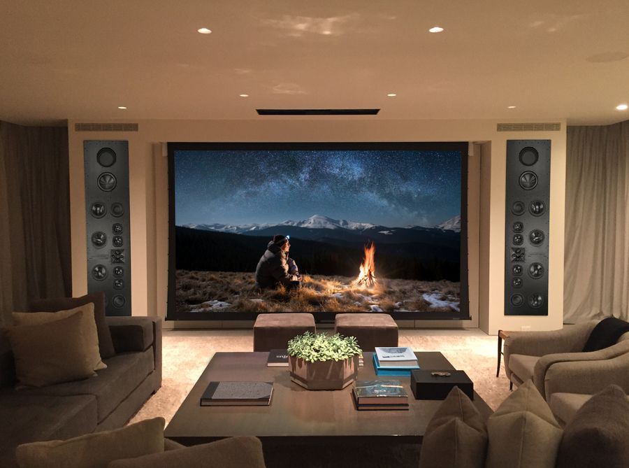 A media room with a large screen surrounded by James Loudspeakers.